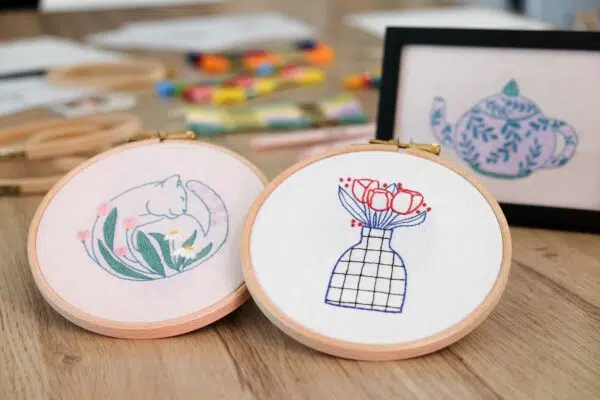 des tambours de broderies avec une broderie chat lové et une broderie vase avec fleurs couleurs douces et designs modernes