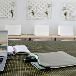 une housse d'ordinateur en tissu upcyclés (extérieur toile de bâche grise, intérieur sweat jersey retourné vert) chez Re Up Circle Nantes